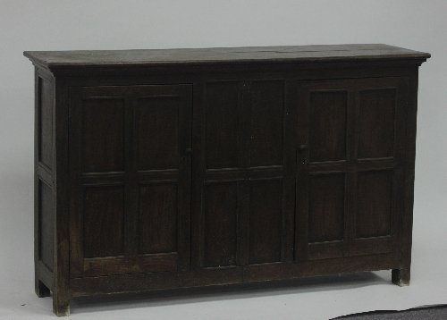 Appraisal: An oak cupboard enclosed by two panelled doors on block