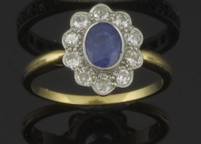 Appraisal: A sapphire and diamond cluster ring The oval shaped sapphire