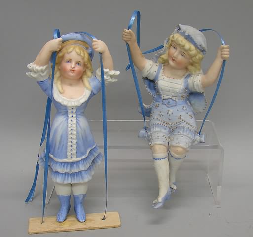 Appraisal: Pair of unmarked female bisque Swing figurines Standing girl is