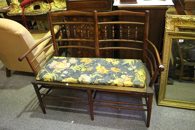 Appraisal: A STAINED BEECH TWO SEATER SETTEE in the manner of