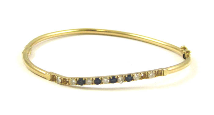 Appraisal: DIAMOND AND SAPPHIRE BANGLE in karat yellow gold with four