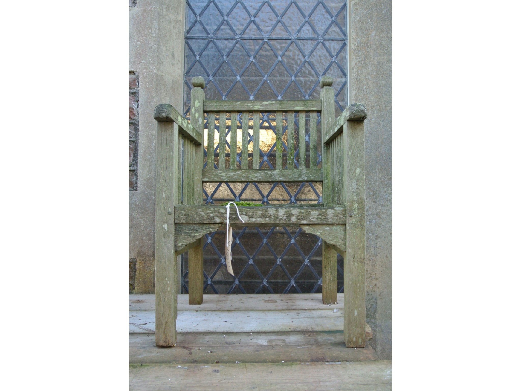 Appraisal: A weathered teak garden arm chair with slatted framework