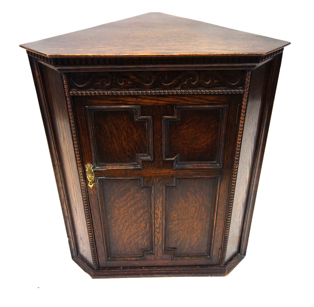 Appraisal: A reproduction oak corner cabinet early th century enclosed by