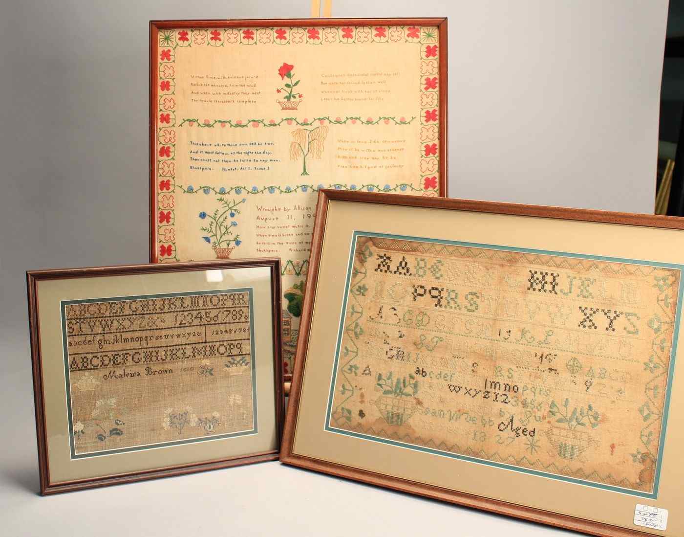 Appraisal: THREE FRAMED SAMPLERS Alphabet and flower baskets Wrought by Malvina