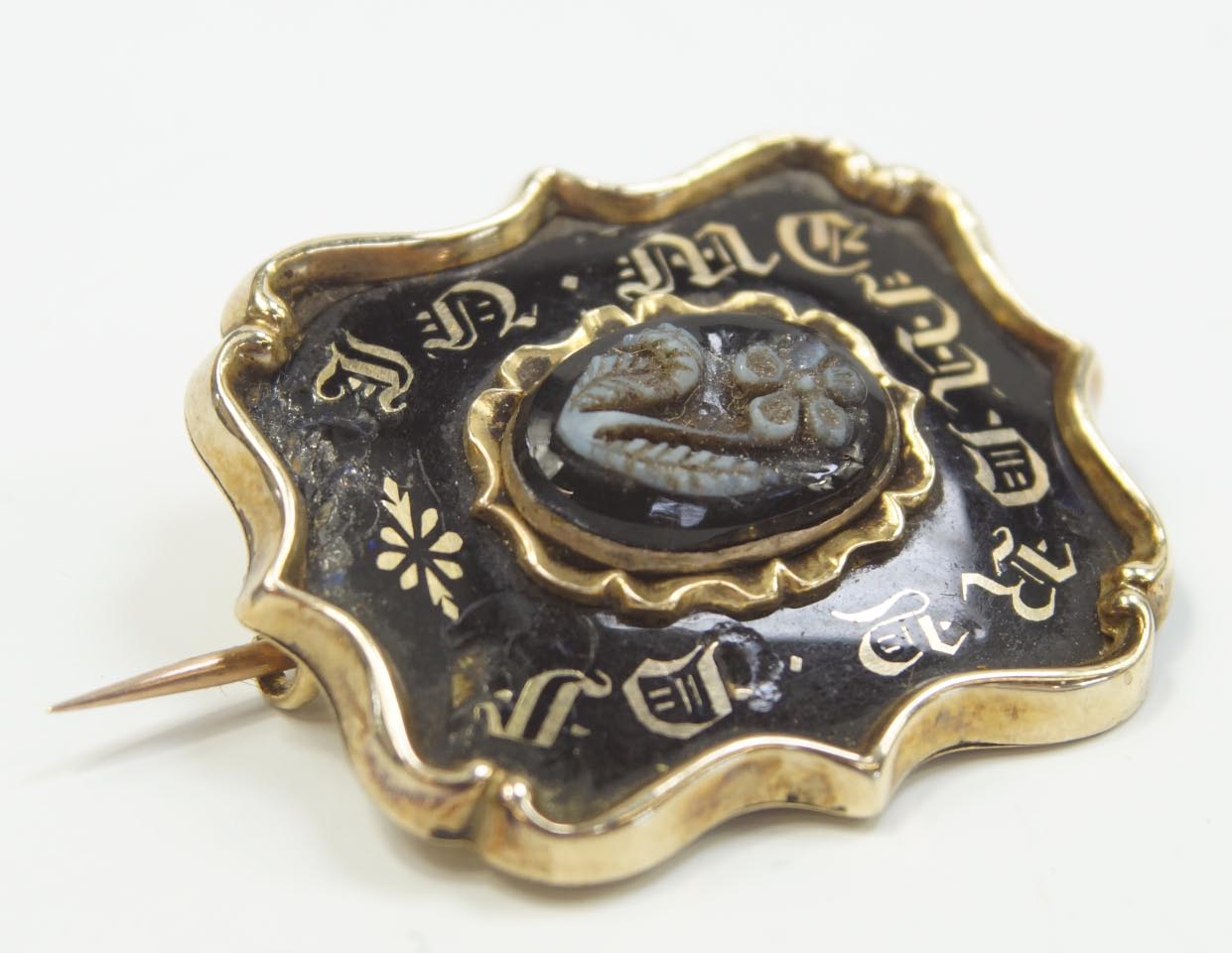 Appraisal: A Victorian memorial brooch black enamel gold colour lettering to