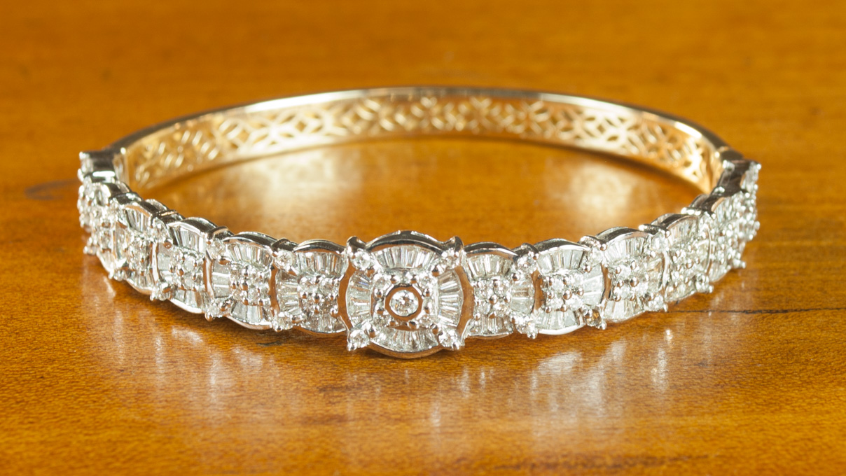 Appraisal: DIAMOND AND FOURTEEN KARAT GOLD BANGLE The oval hinged white