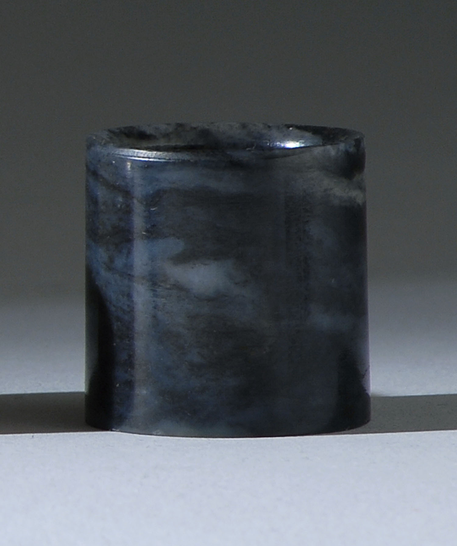 Appraisal: BLACK AND GRAY JADE THUMB RING th CenturyIn simple cylinder