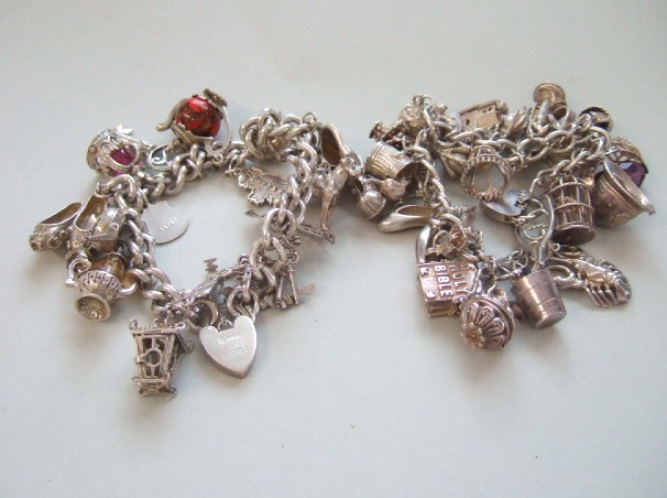 Appraisal: Two silver curb link charm bracelets each with a variety