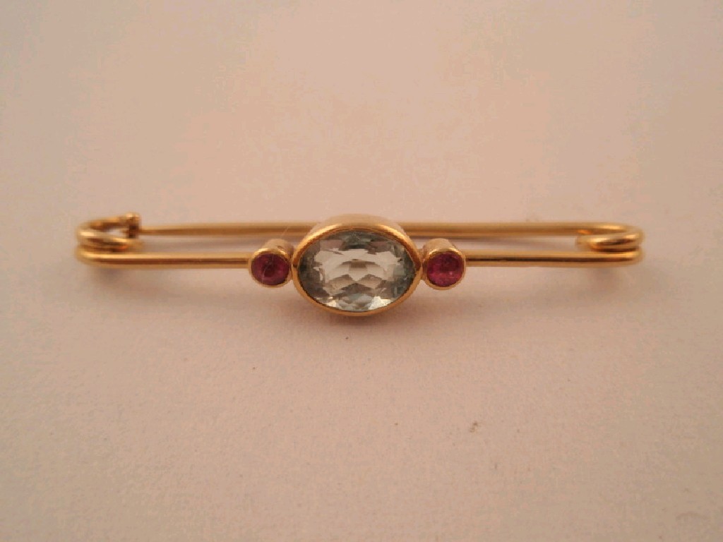 Appraisal: A bar brooch set with a central aquamarine flanked by