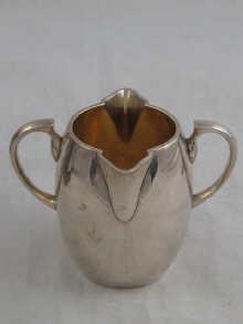 Appraisal: A Victorian silver barrel shaped two lipped two handled cream