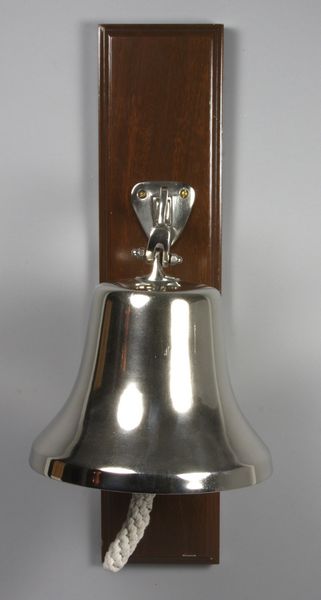 Appraisal: Aluminum ship's bell with bracket mounted to mahogany board fitted