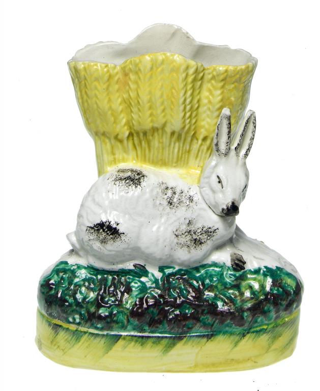 Appraisal: A STAFFORDSHIRE EARTHENWARE FLATBACK RABBIT AND WHEATSHEAF SPILL HOLDER sponged