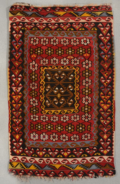 Appraisal: A TURKISH KELIM with multicoloured banded decoration on a red