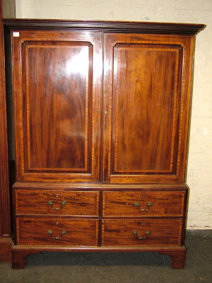 Appraisal: A mahogany linen press th century the moulded cornice above