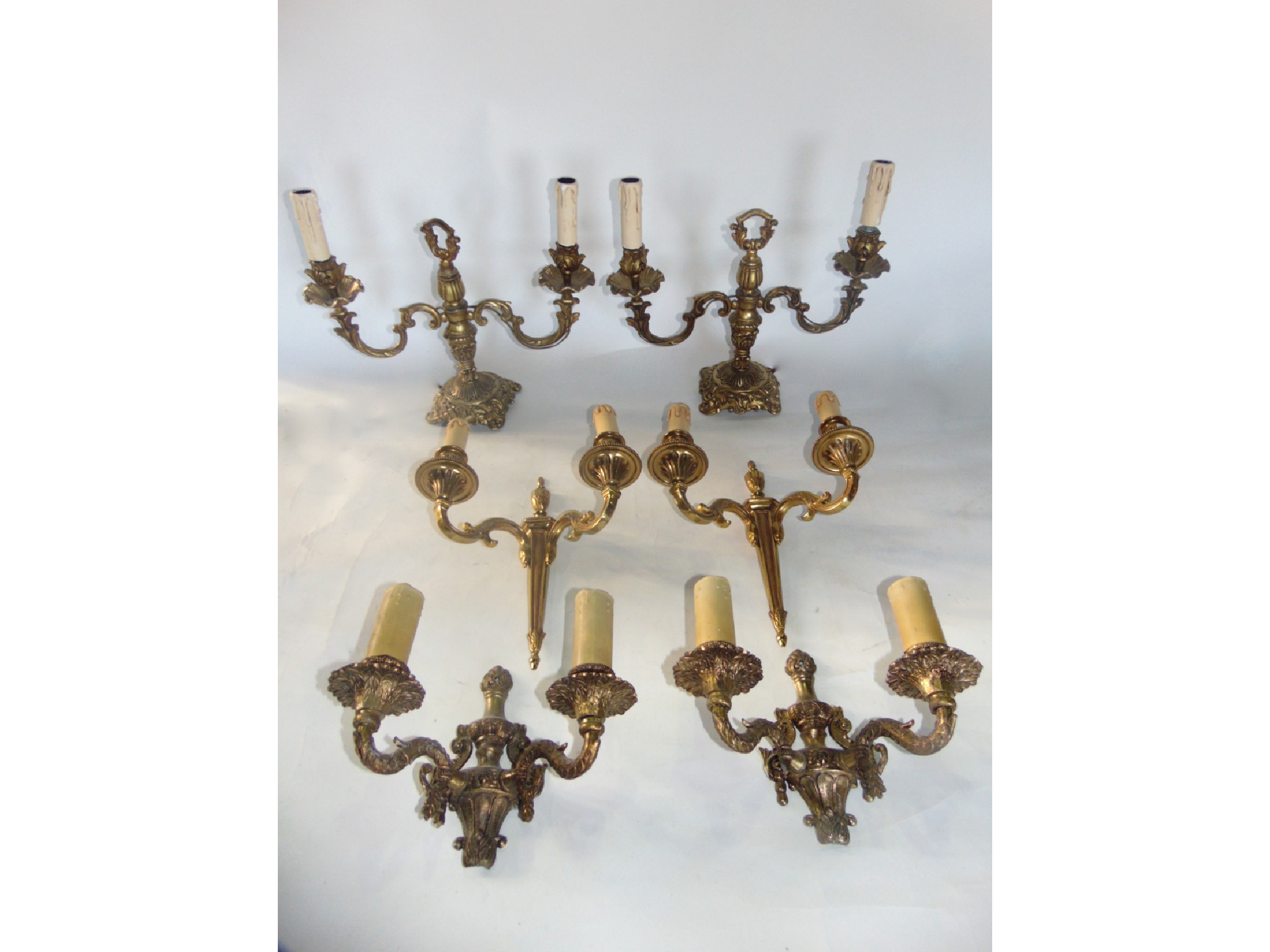 Appraisal: A pair of cast brass electrified two divisional candelabra further