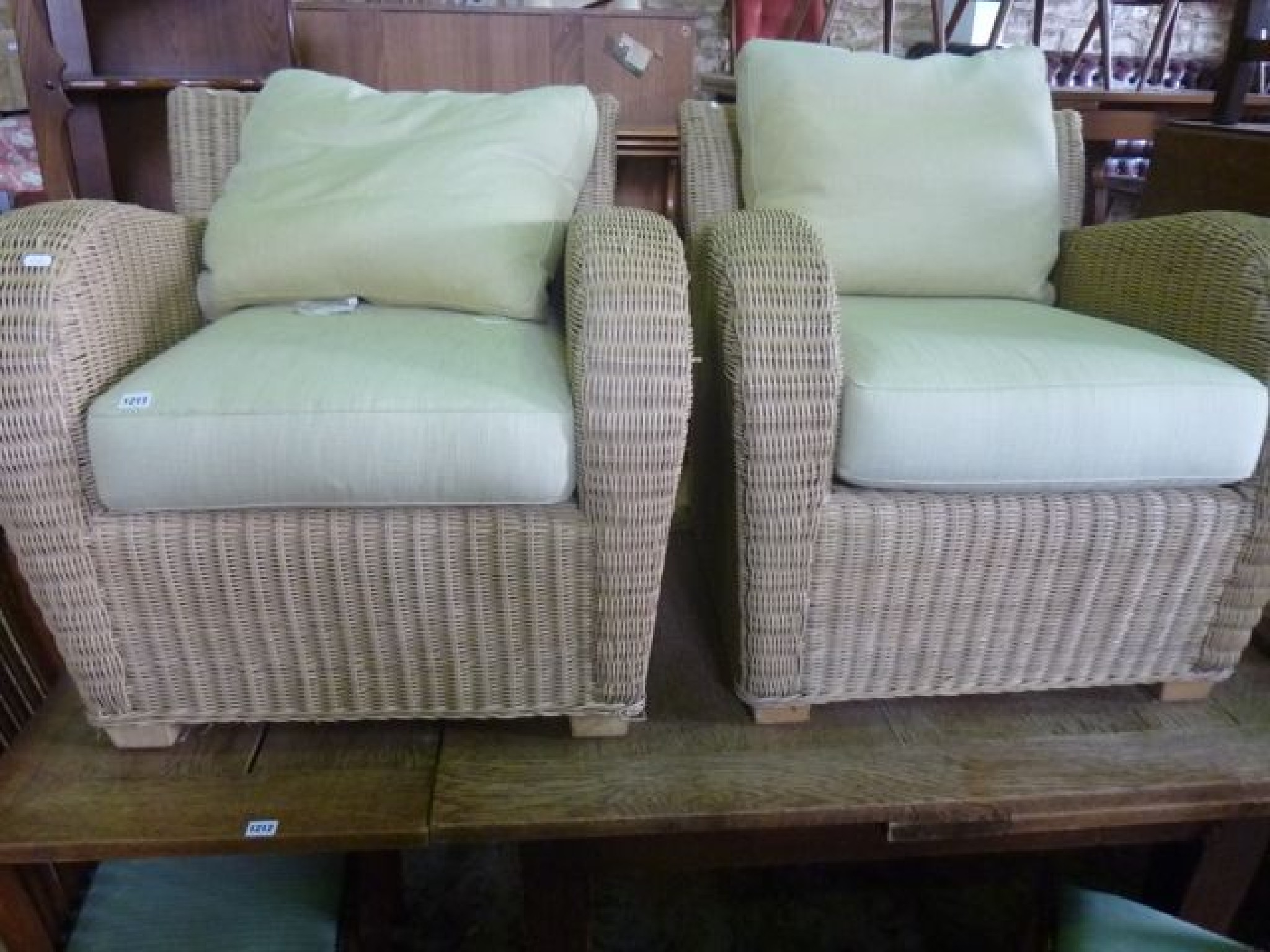 Appraisal: A pair of contemporary wicker conservatory chairs with shaped arms