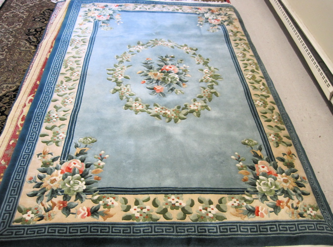 Appraisal: MAINLAND CHINESE CARPET featuring a floral wreath medallion centered on