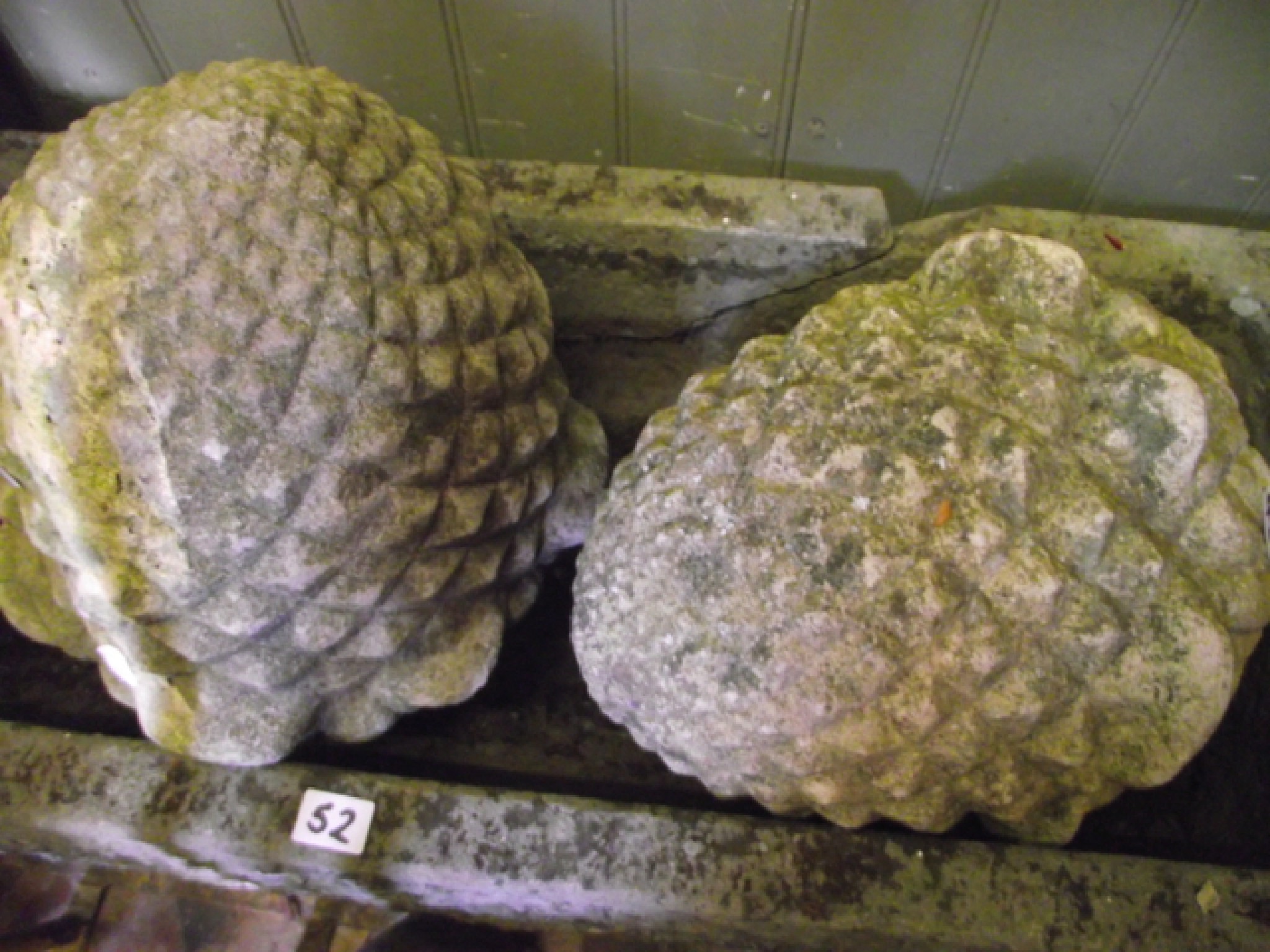 Appraisal: A pair of weathered carved stone pineapple finials cm high