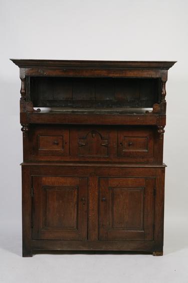 Appraisal: AN OAK TRIDARN STYLE CUPBOARD with a moulded cornice above