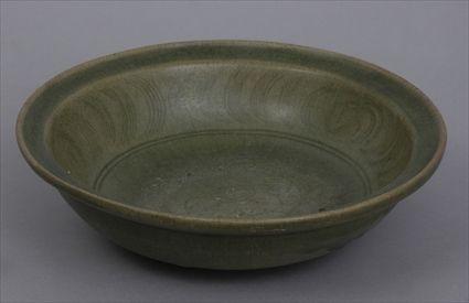 Appraisal: THAI SAWANKALOKE INCISED CELADON-GLAZED POTTERY FOOTED BOWL The interior with