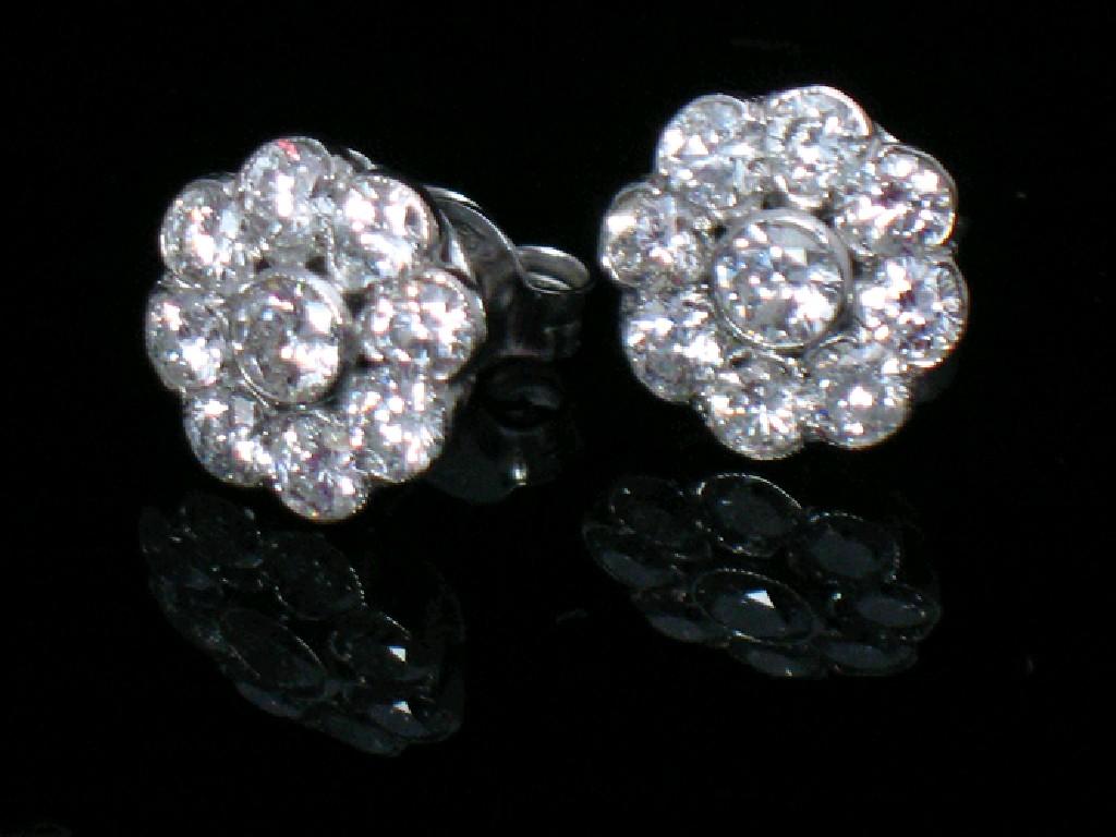 Appraisal: A PAIR OF DIAMOND CLUSTER EARRINGS in a rub-over setting