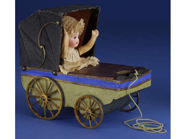 Appraisal: Pull Toy Mechanical Carriage with Baby Germany ca leatherette covered