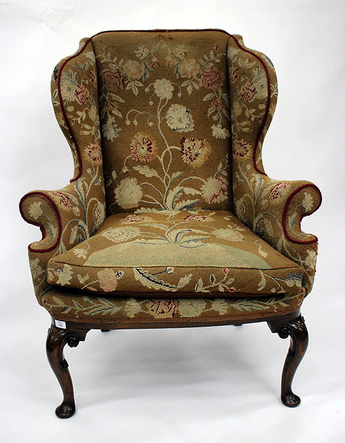 Appraisal: AN ANTIQUE GEORGIAN STYLE WING BACK ARMCHAIR with walnut scrolling