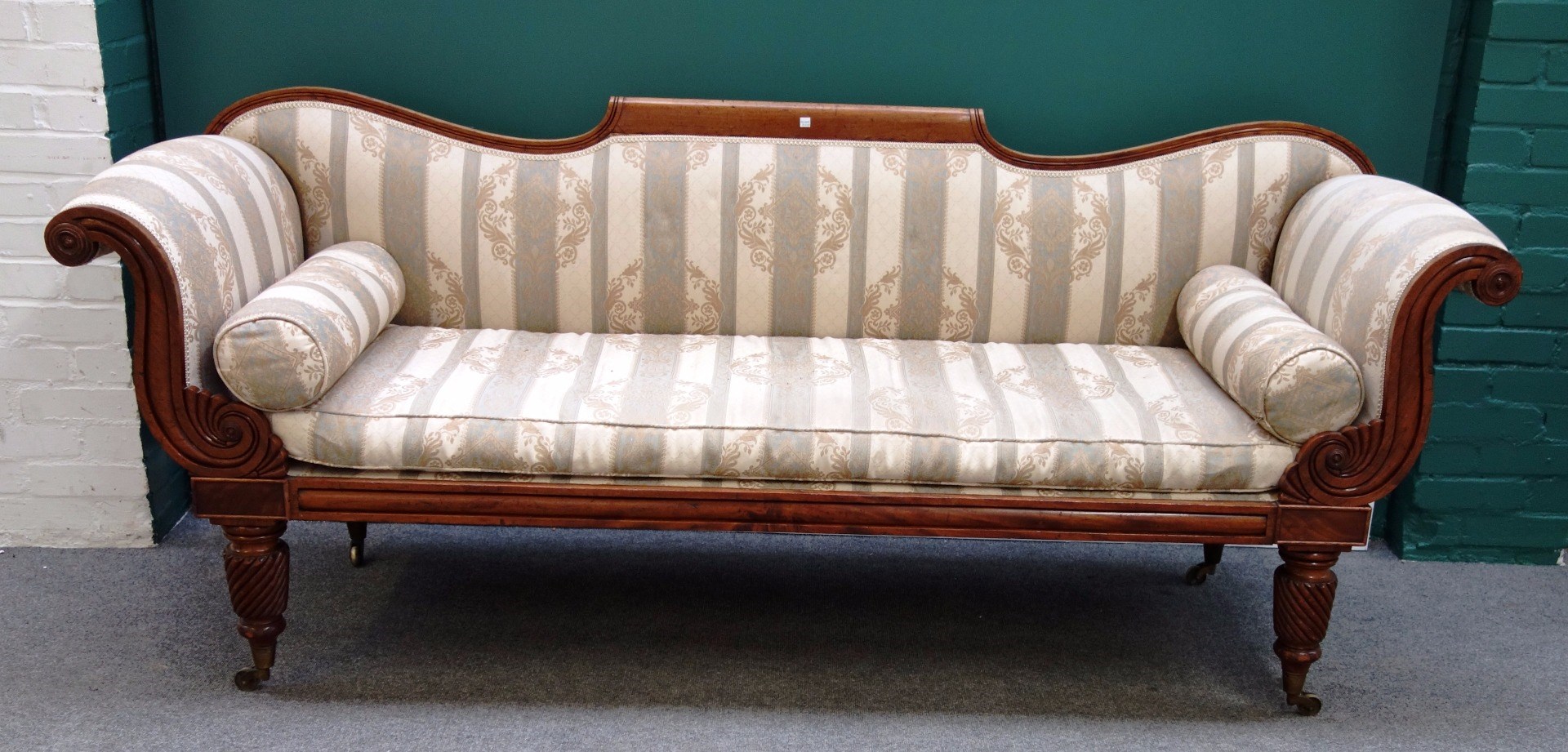 Appraisal: A Regency mahogany framed sofa with scroll ends and straight