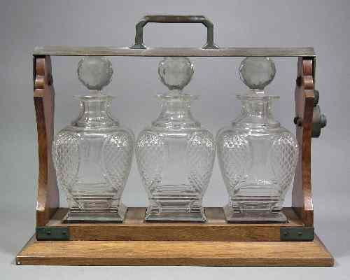 Appraisal: An early th century oak and plated metal mounted three-bottle