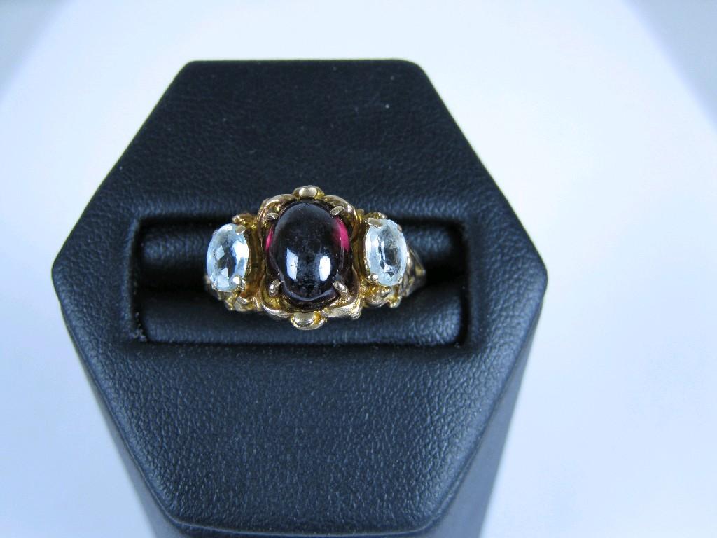 Appraisal: An Almandine Garnet and Aquamarine Ring the central cabochon claw-set