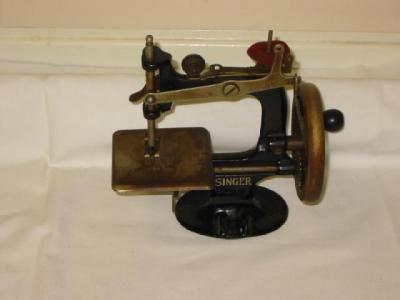 Appraisal: A Singer toy hand sewing machine with painted cast iron