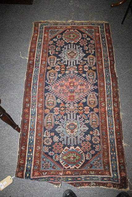 Appraisal: AN EASTERN WOOL RUG with central medallions and running borders