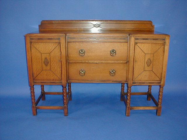 Appraisal: An oak sideboard with an arrangement of two drawers flanked