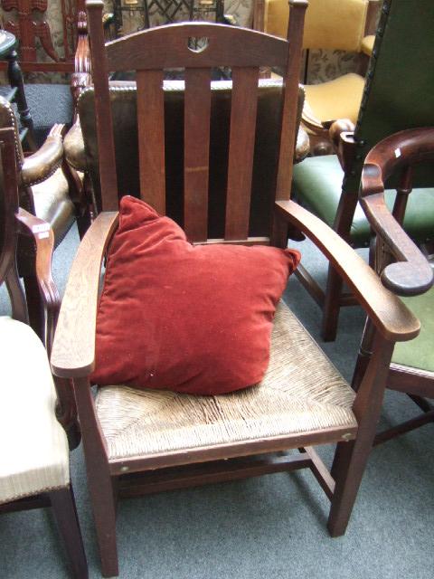 Appraisal: An Arts and Crafts oak framed open armchair with heart