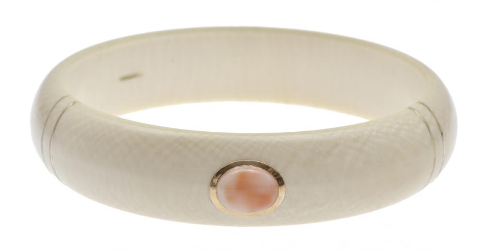 Appraisal: AN IVORY AND CORAL BANGLE decorated with oval coral cut