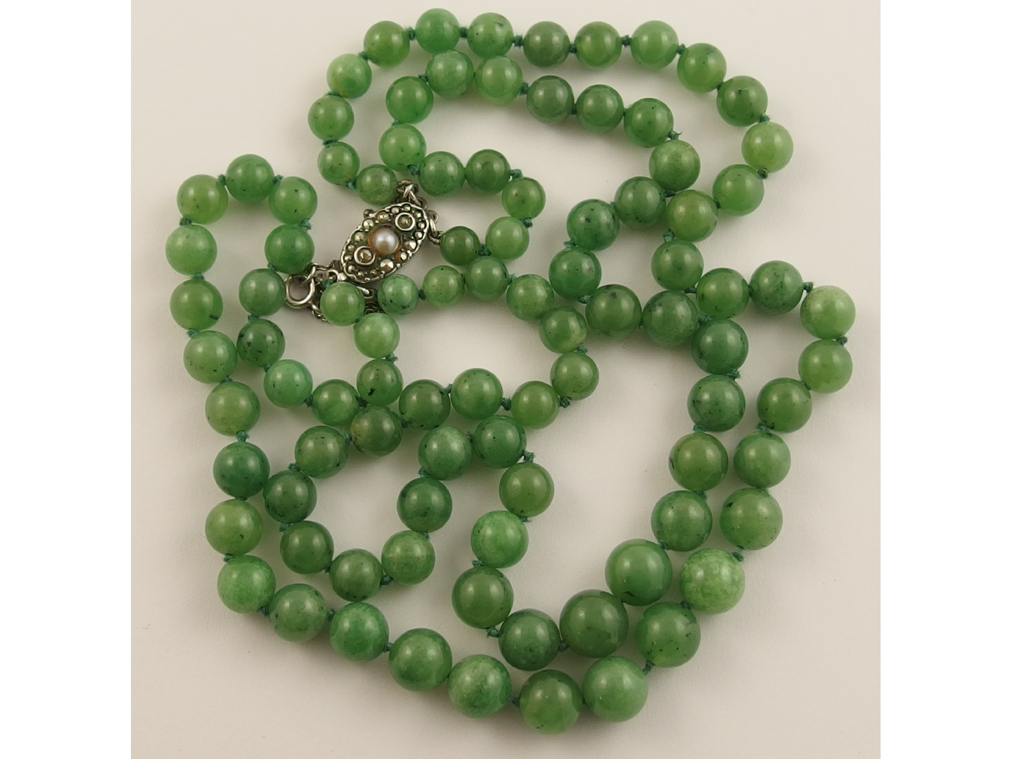 Appraisal: A double string of Chinese green hardstone beadsthe round beads