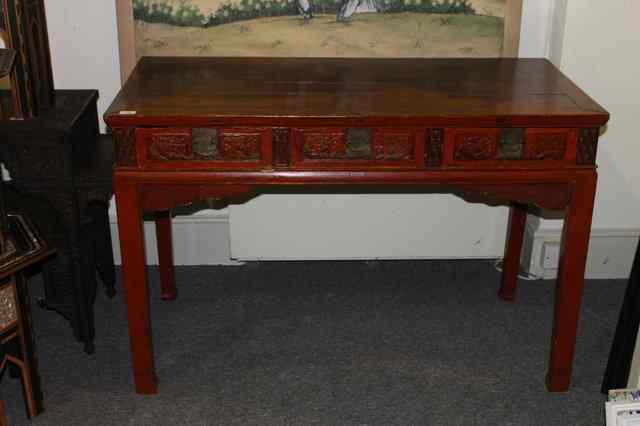 Appraisal: A CHINESE RED LACQUER SIDE TABLE fitted three drawers with