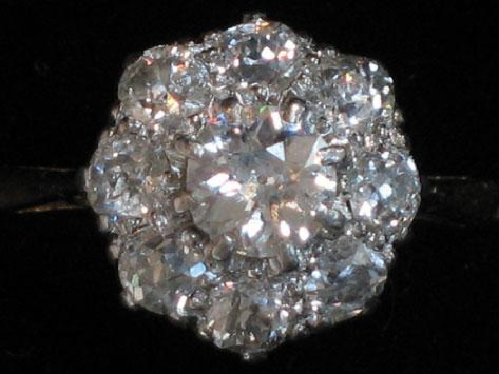 Appraisal: A DIAMOND CLUSTER RING the central old-cut diamond claw-set and