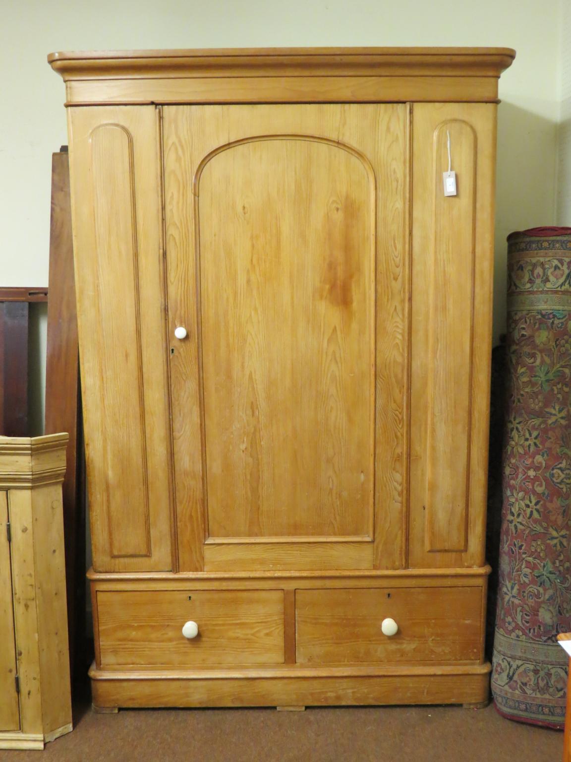 Appraisal: A Victorian waxed pine wardrobe three-quarter length panelled door enclosing