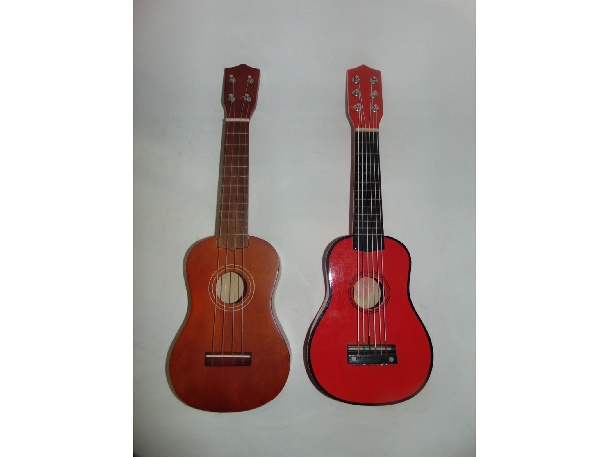 Appraisal: A timber six string Ukulele with red painted finish together