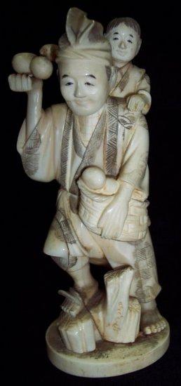 Appraisal: A Japanese carved ivory okimono a fruit seller with boy