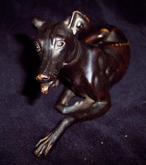 Appraisal: A bronze figure of a recumbent whippet with sprung jaw