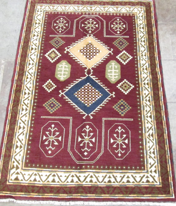 Appraisal: HAND KNOTTED ORIENTAL CARPET Indo-Caucasian burgundy field ' x '