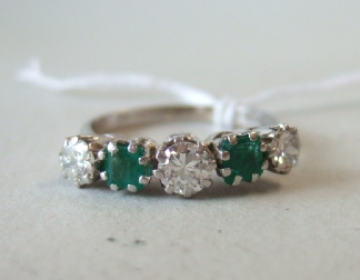 Appraisal: A platinum diamond and emerald set five stone ring claw