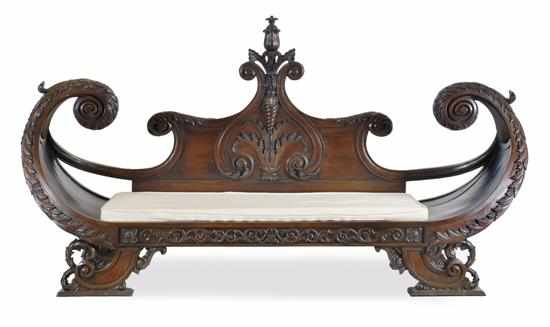 Appraisal: A CARVED MAHOGANY EGYPTIAN MOTIF CHAISE LONGUE The boat-shaped rectangular