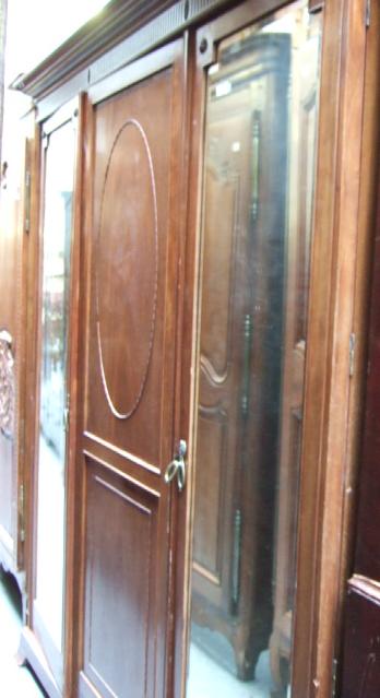 Appraisal: An early th century mahogany triple wardrobe the stepped cornice