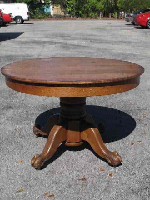 Appraisal: '' round oak pedestal table with claw feet Measures ''