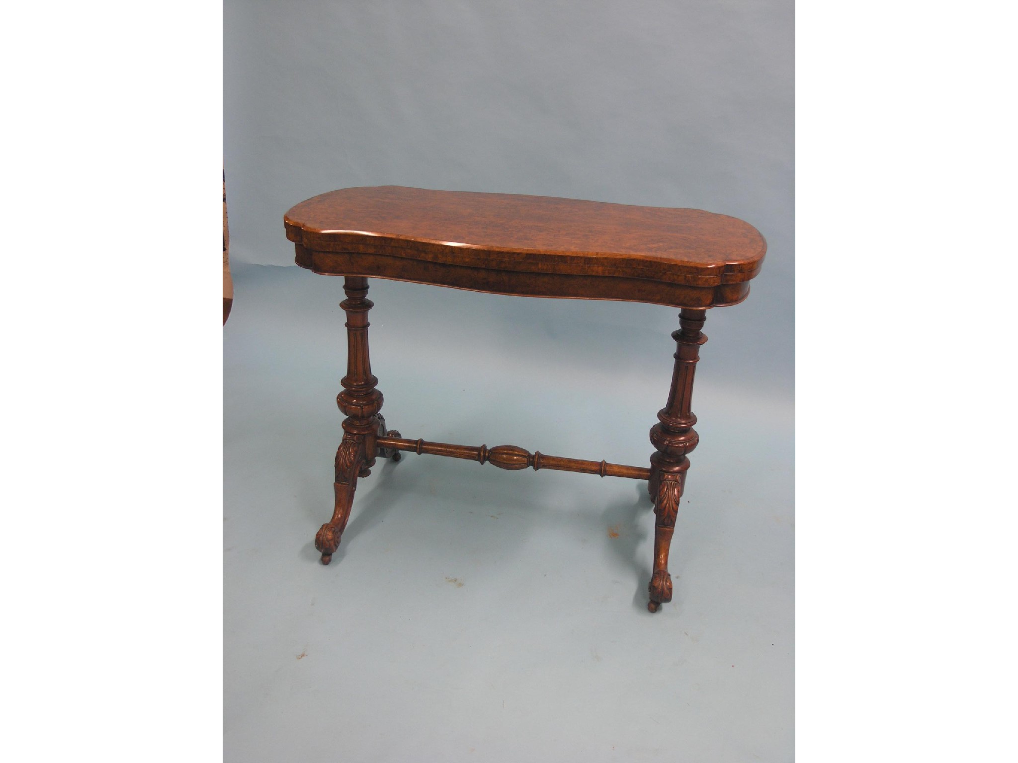 Appraisal: A Victorian burr walnut card table serpentine-shaped top with baize