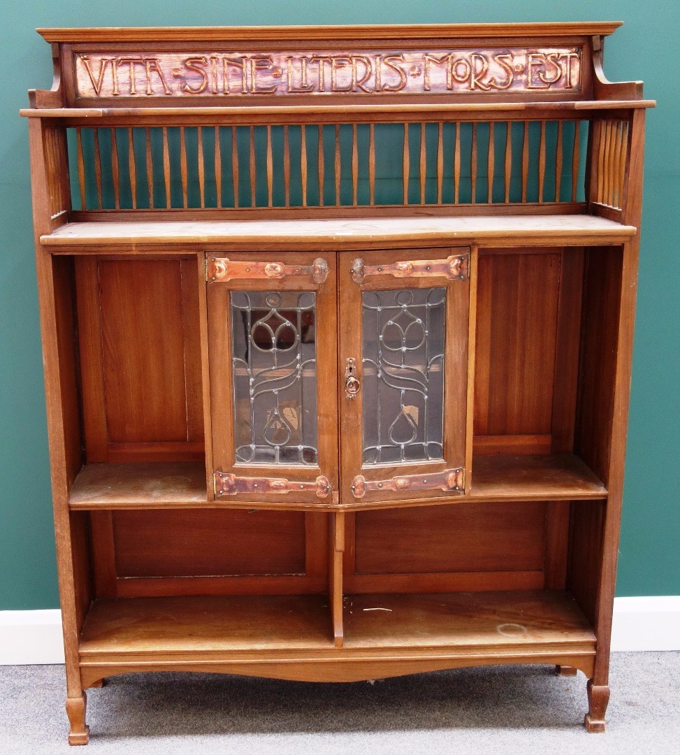 Appraisal: An Arts and Crafts copper mounted fruitwood bookcase cupboard the