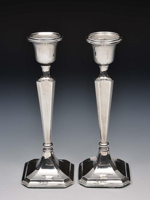 Appraisal: Pair of silver candlestickswith tapering stems and square cut canted